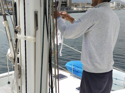 Rigger inspecting the mast and deck gear of a catamaran – SailorOne